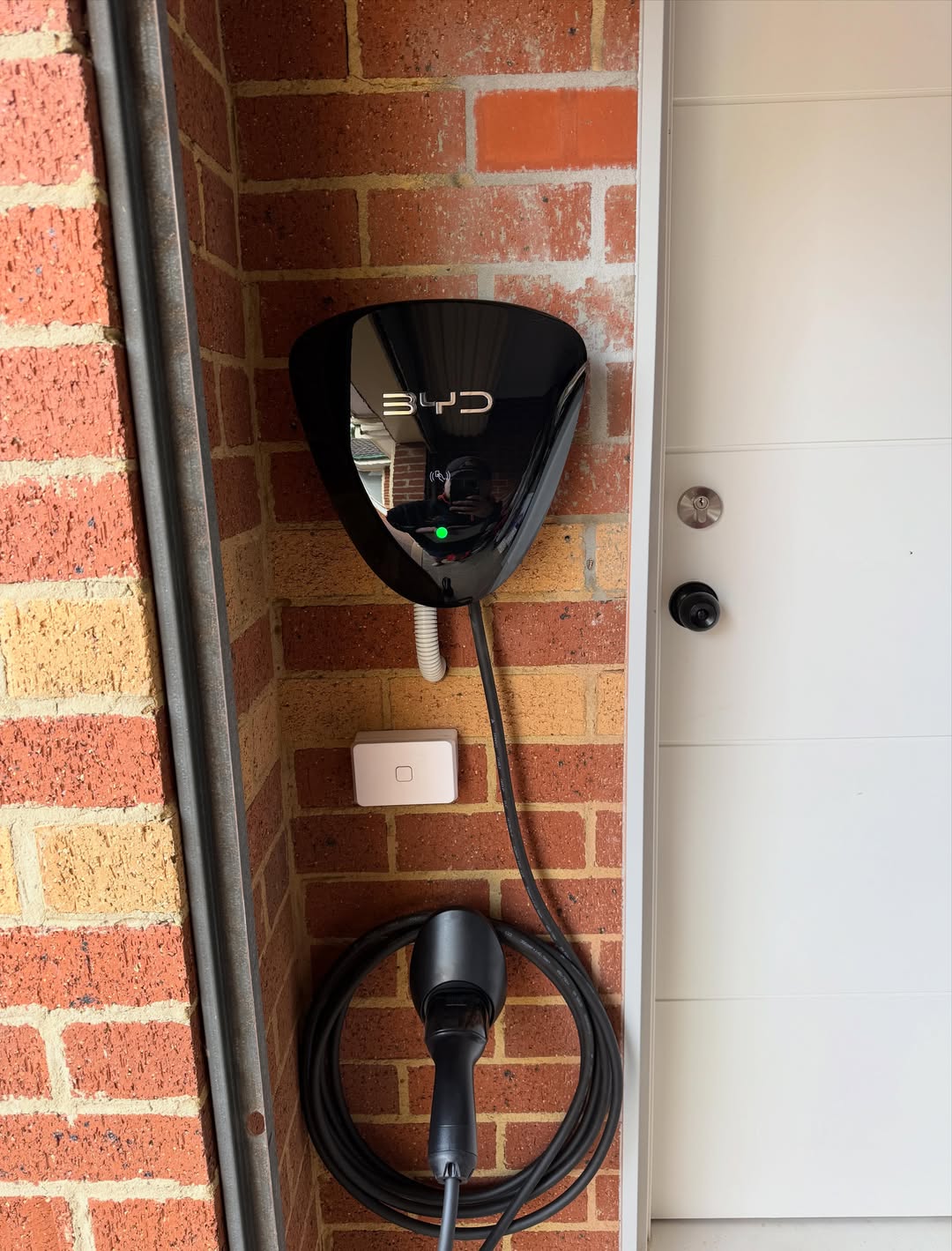 BYD home wall charger mounted on brick wall — EV charging installation Melbourne
